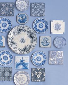 an assortment of blue and white plates arranged in the shape of a clock on a wall