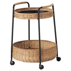 a wicker serving cart with wheels and two baskets on the bottom one is black