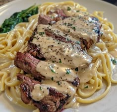 steak with gravy and noodles on a white plate