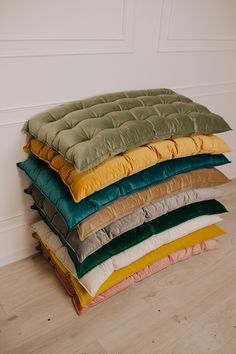 a stack of pillows sitting on top of a wooden floor