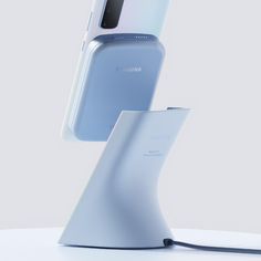 the samsung foldable phone is displayed on a white surface with an external charging dock