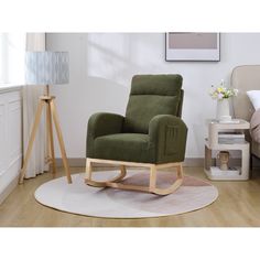 a green rocking chair sitting on top of a wooden floor next to a white rug