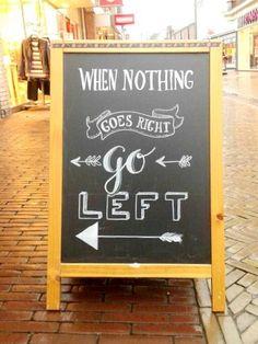 a sign that is on the sidewalk in front of a store saying, when nothing goes right go left