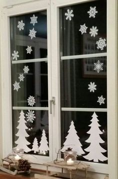 a window decorated with snowflakes and christmas trees