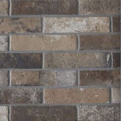 a brick wall made out of several different colors and sizes, including brown, tan, gray