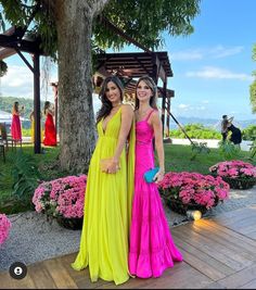 two women standing next to each other in dresses