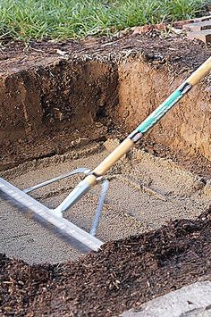 a shovel is laying in the ground next to a hole