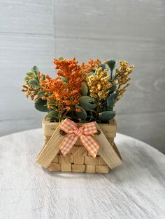 an arrangement of flowers in a basket on a table