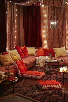 a living room filled with lots of furniture and lights on the wall above it's windows