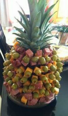 a large pineapple sitting on top of a table next to a bowl of fruit