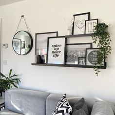 a living room filled with furniture and framed pictures on the wall next to a couch