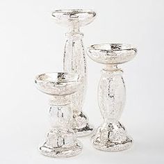 three glass candlesticks sitting next to each other