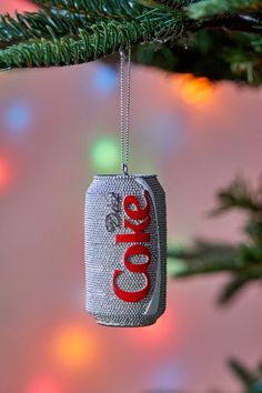 an ornament hanging from a christmas tree with the word coke on it's side