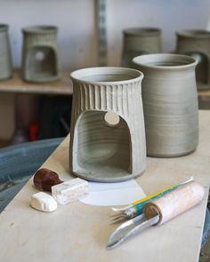 some pottery is sitting on a table with tools