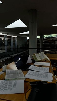 there are many books on the table in the library and one is open to read