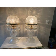 two glass lamps sitting on top of a table