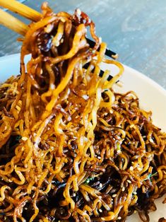 some noodles are piled on top of each other with chopsticks in the middle