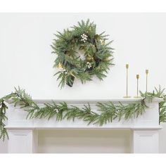 a christmas wreath is hanging on the mantle