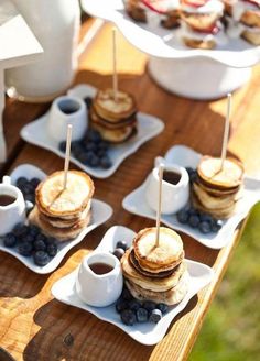 pancakes and blueberries are arranged on small plates