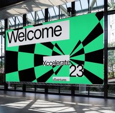 a large green sign with black and white designs on it's side that reads welcome accelerate 23