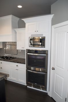 a kitchen with white cabinets and stainless steel appliances