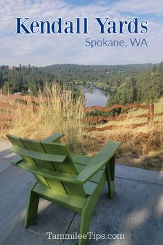 a green park bench sitting on top of a cement floor next to a field and trees