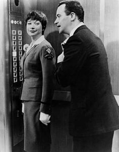 an old photo of two people standing in front of a control room with buttons on the wall