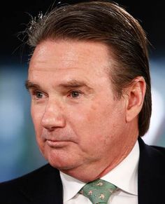 a close up of a person wearing a suit and tie with a serious look on his face