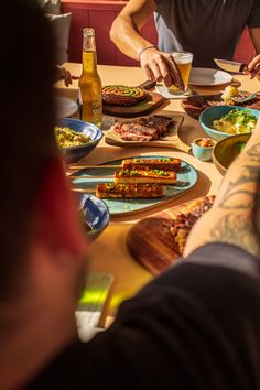 a group of people sitting around a table with food and drinks on top of it