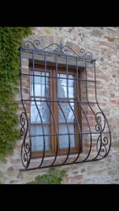 a window with iron bars in front of a stone building