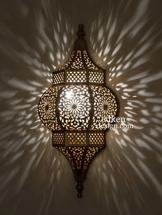 an intricately designed light fixture casts a shadow on the wall