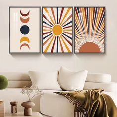 three paintings on the wall in a living room