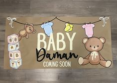 a baby shower mat with teddy bears and clothes hanging on a line that says, baby barn coming soon