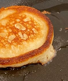 a close up of a pancake on a stove with oil coming off the top