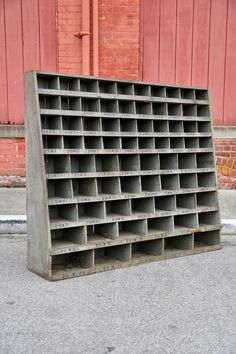 a large metal shelf sitting in front of a red building