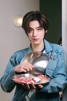 a man holding a plate with candy in it