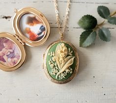 This is a large oval shaped locket necklace in gold finish with a beautifully detailed lily of the valley on a sage green background. This locket is also available in rose gold, bright silver, antiqued silver and antiqued gold finish). The locket measures approx. 1.9'' x 1.4'' (48mm x 35mm) and has beautiful engraving designs on both the front and back. The locket can be opened to hold 2 photos or or hide tiny treasures. How to Send us Photo (s) After your order is submitted, please send us an E Luxury Green Locket Necklaces, Luxury Green Locket Necklace, Green Necklace Locket, Green Lily Of The Valley, Engraving Designs, Green Lily, Gold Locket Necklace, Gold Locket, Photo Locket