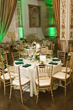 the tables are set up with white linens and green sashes for an elegant reception