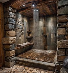 a bathroom with stone walls and flooring is shown in this image, it has a shower