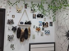 a wall with pictures and animal heads hanging on it's sides, along with plants