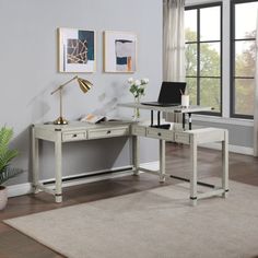 a white desk with a laptop on it in front of a window and potted plant