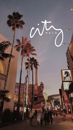 people walking down the street in front of some buildings and palm trees at night time