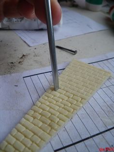 a person using a metal tool to cut out squares