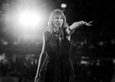 a black and white photo of a woman holding her hand out in front of the camera