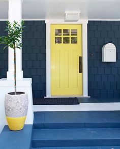 a yellow front door on a blue house