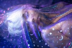 a woman laying on top of a bed covered in stars