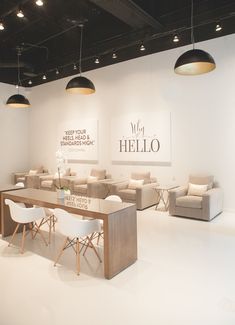 the interior of a furniture store with white chairs and couches, tables and chandeliers