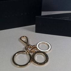 a pair of gold colored metal scissors on a white table with a black box in the background