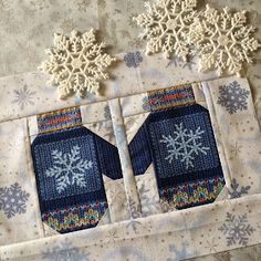 two snowflakes are on top of a quilt