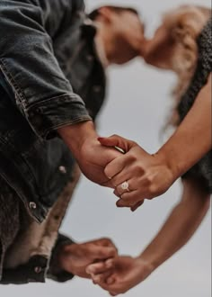 a man and woman holding hands while standing next to each other